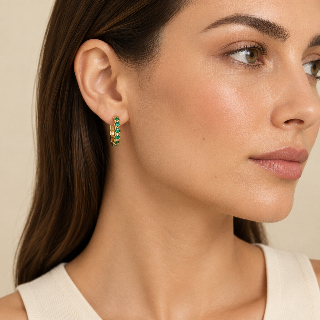 Model wearing green-stone gold-tone huggie earrings